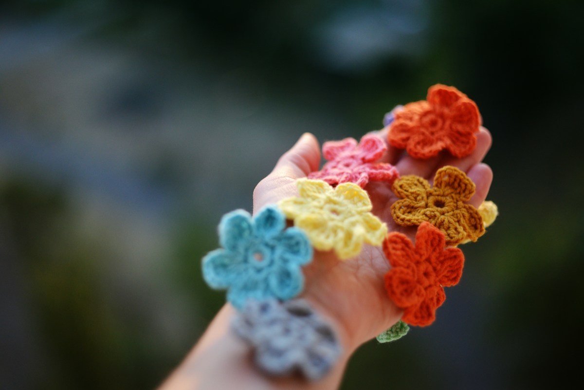 Crochet bag charms made with colorful yarn and handmade crochet flowers